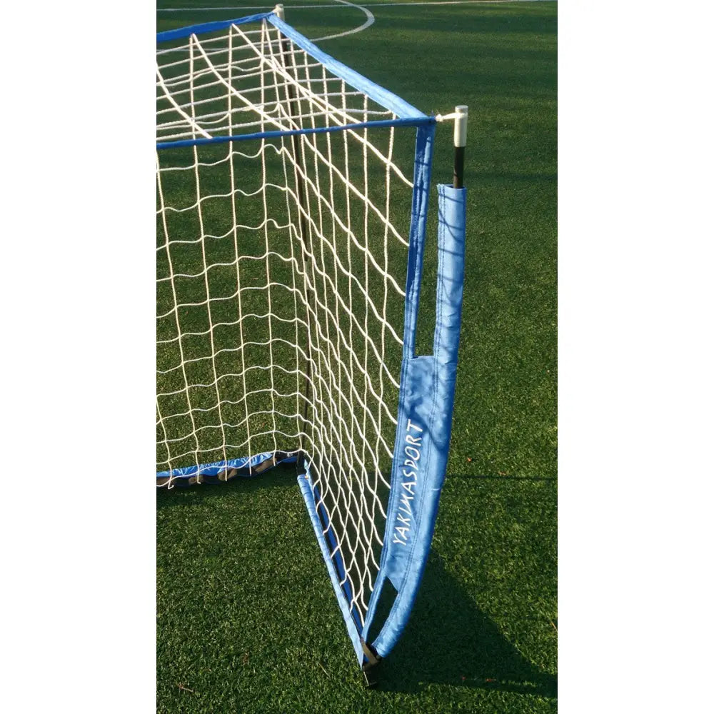 Sammenleggbar port UNI Gnomen, blått og hvitt fotballmål med polstret kant sett bakfra på kunstgress.