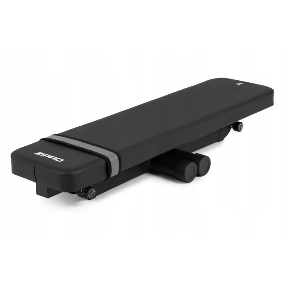 Sammenleggbar treningsbenk fra Zipro, sidevisning av kompakt, svart, polstret benk med grått bånd og logo.