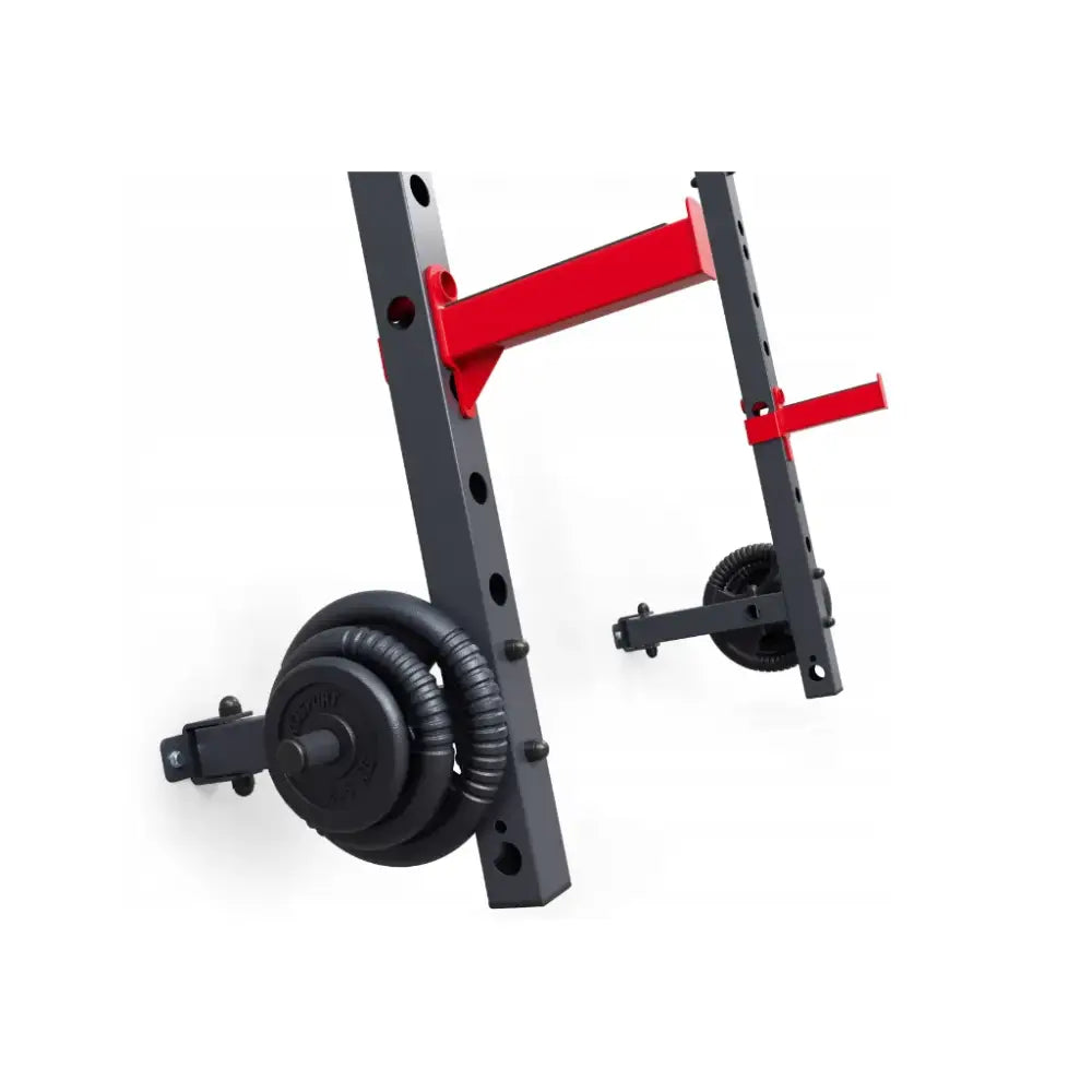 Sammenleggbar veggmontert rack med sorte metallstativ, røde armer og vektplater på oppbevaringspinner.