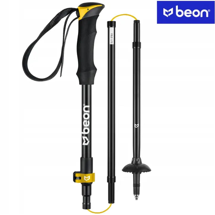 Sammenleggbar svart vandrestav i aluminium, delt opp med gul låsemekanisme og ergonomisk håndtak.
