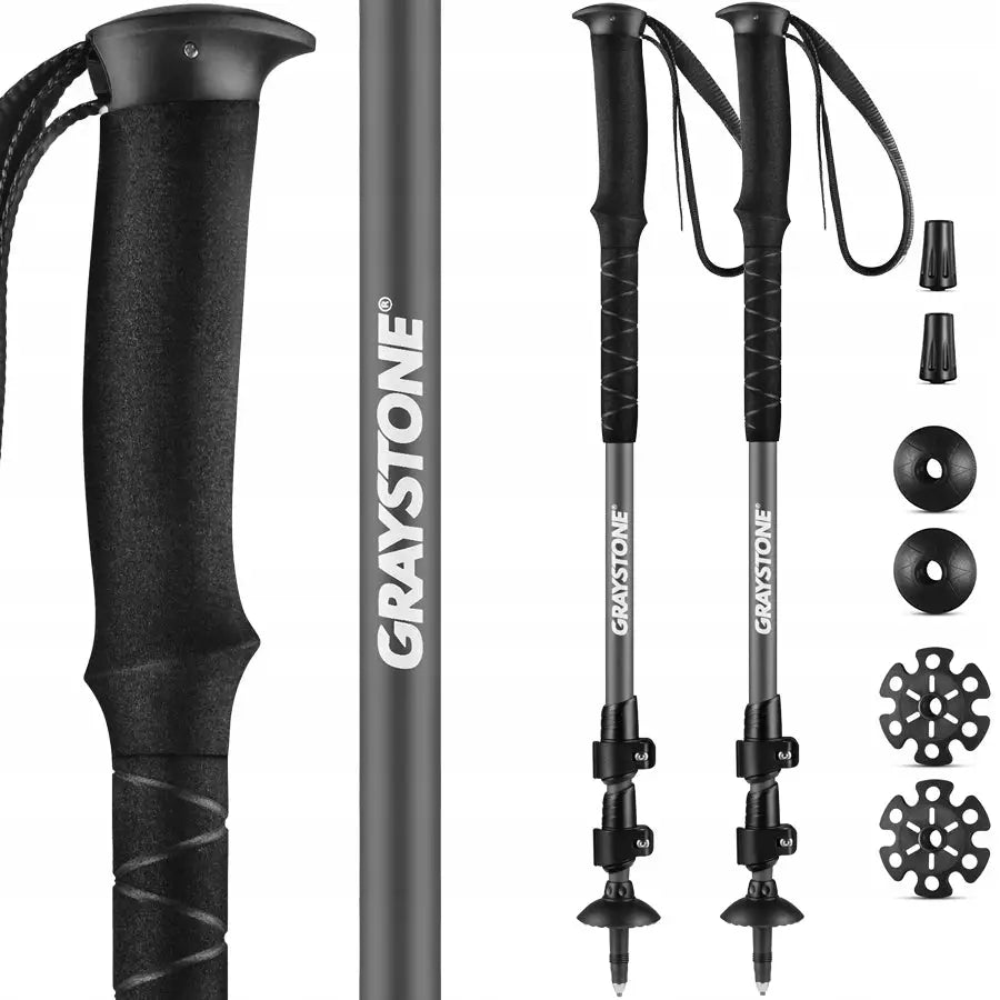 Sammenleggbare trekkingstaver i svart og grå aluminium med ergonomiske håndtak, låser og utskiftbare trinser.