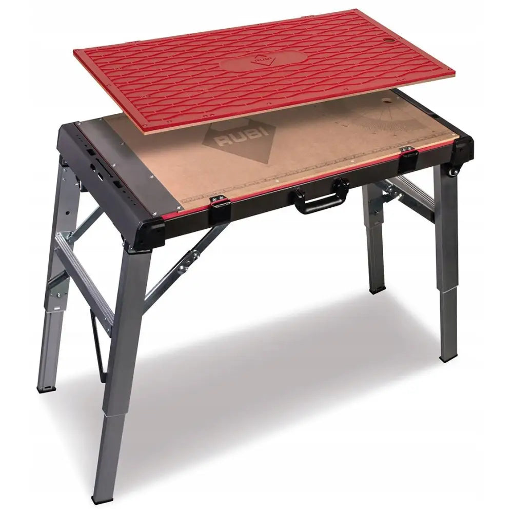 Sammenslåbart multifunksjons arbeidsbord med grå ben, rød arbeidsplate løftet over lys treflate, sett skrått.