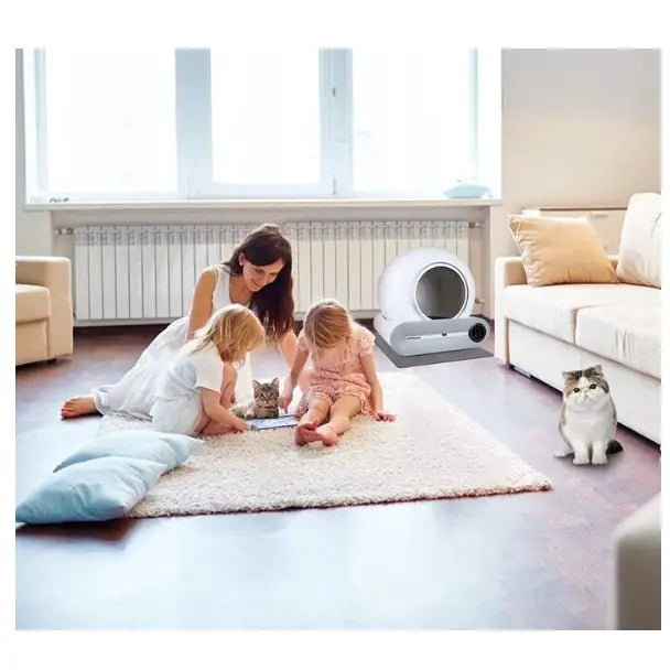 Selvrensende Smart Wifi Kattetoalett (F054) i bruk i stue, med katt og familie som leker på teppet foran enheten.