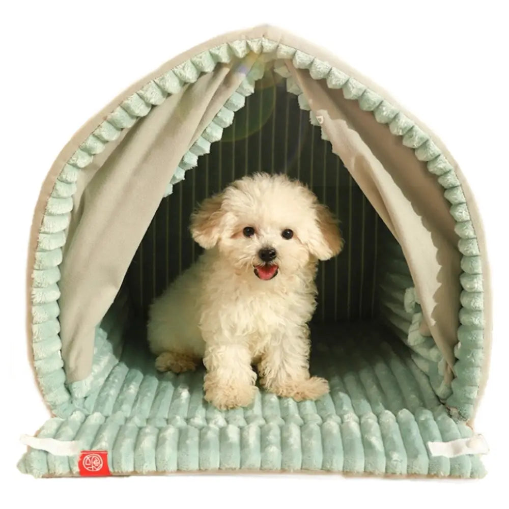 Sengeplass for hund eller katt, hvit valp sitter i lysegrønt teltformet plysjhus med stripete vattert stoff, frontvisning.