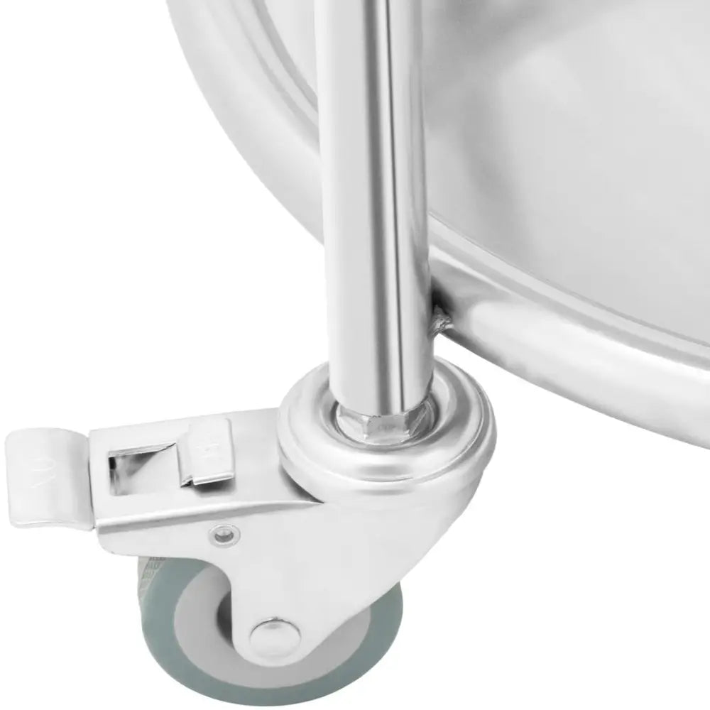 Grått hjul med brems og lysegrå gummibelegg, festet til kromfarget rundstativ for serveringsvogn.