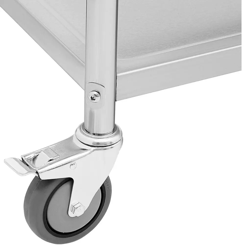 Serveringsvogn i rustfritt stål, detalj av hjul med lås festet til metallbenet i rammehjørnet.