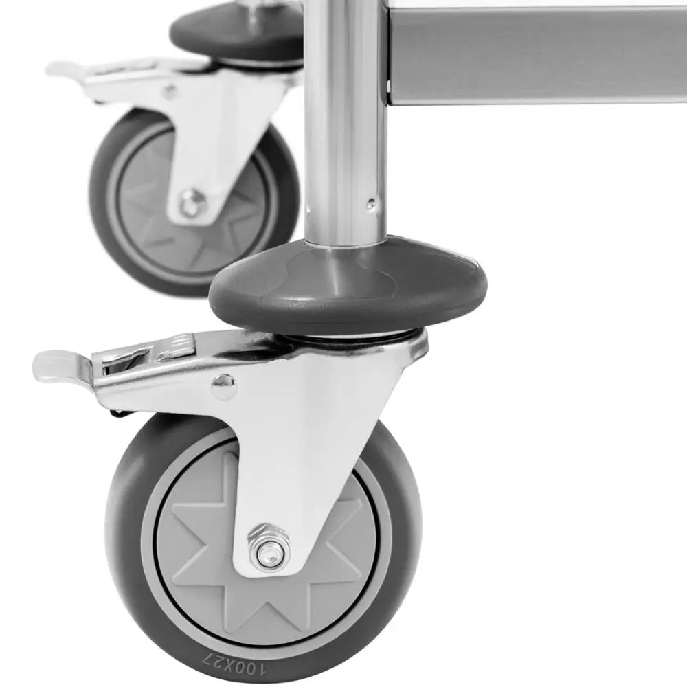 Serveringsvogn, nærbilde av grå svingbare hjul med bremser og tydelig visning av feste og låsemekanisme.