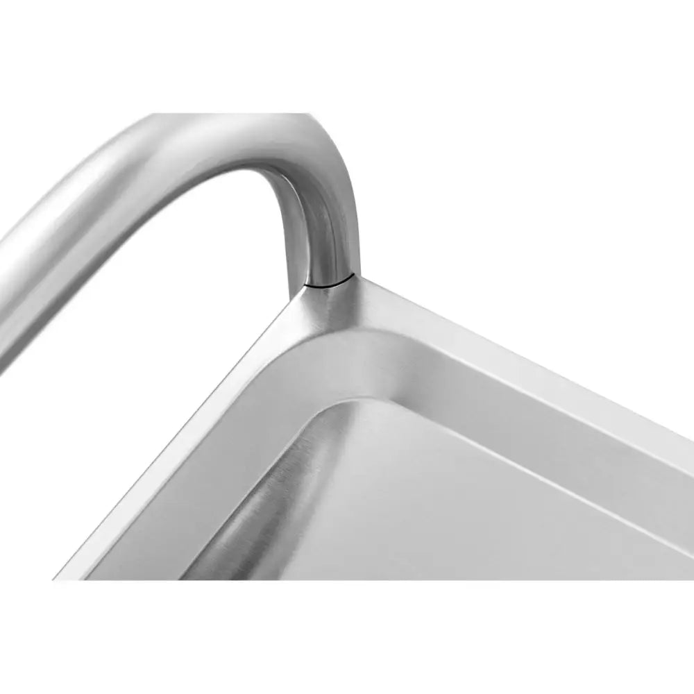 Serveringsvogn i rustfritt stål, nærbilde av avrundet håndtak og glatt hyllekant i børstet finish.