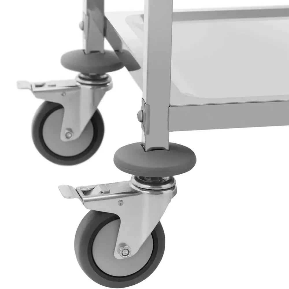 Serveringsvogn, detalj av to grå gummihjul med bremser og avrundede beskyttelsesringer på metallunderstellet.