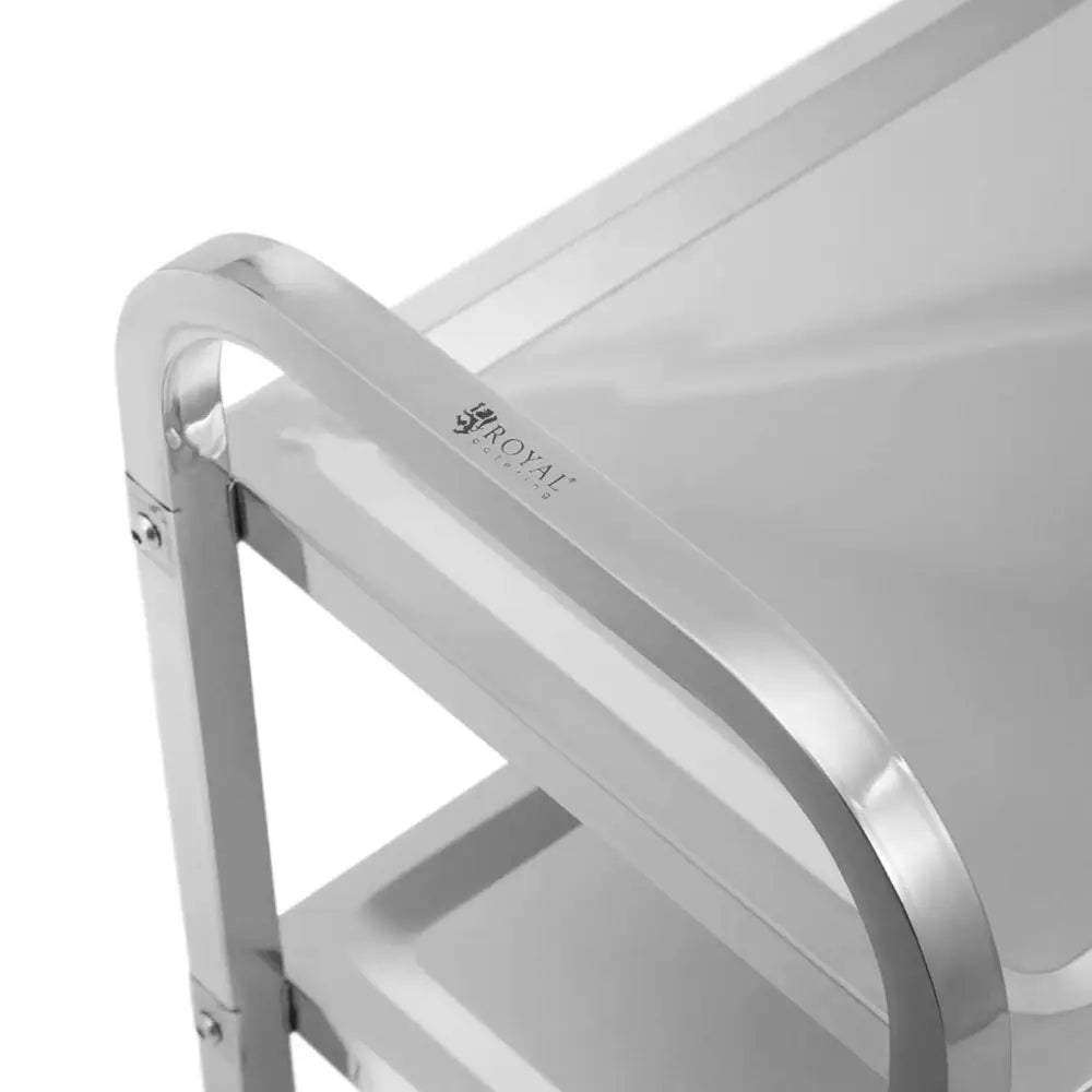 Serveringsvogn i blankt metall, nærbilde av hjørne med gravert logo på håndtak og to solide hyller.