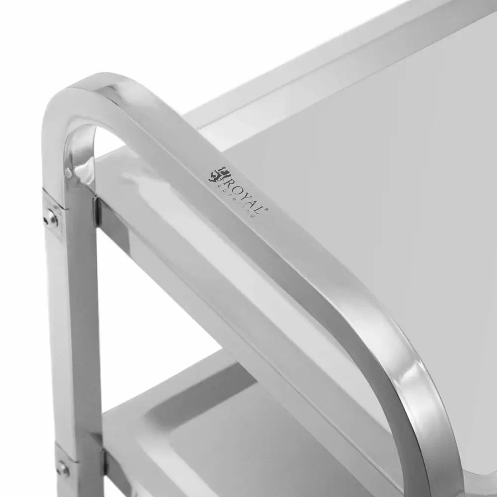 Serveringsvogn med 3 hyller, nærbilde av sølvfarget metallhjørne og Royal Catering-logo på håndtaket.