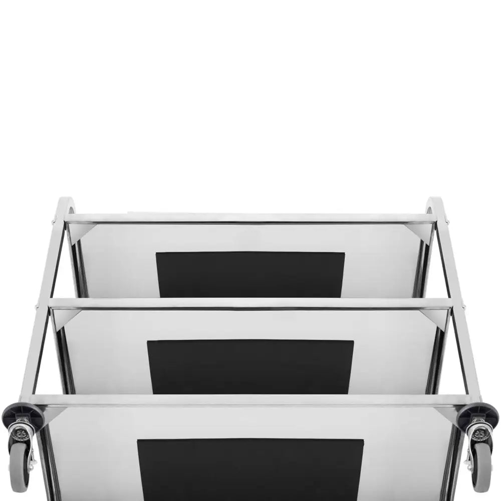 Serveringsvogn med tre hyller, sett ovenfra, viser svarte innleggsplater og to hjul med bremser nederst.