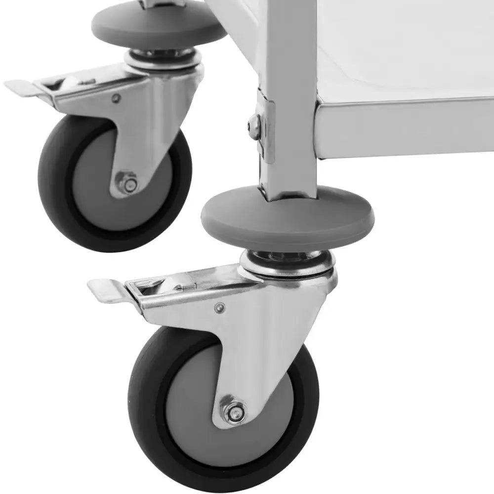 Serveringsvogn, nærbilde av grå gummihjul med metallbeslag festet til hvit ramme og støtdempende plast.