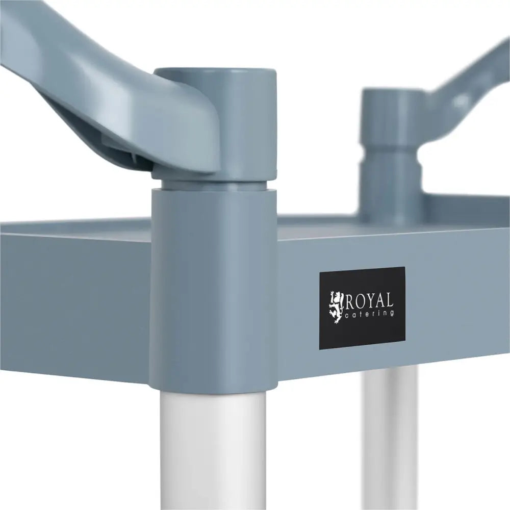 Serveringsvogn til catering, nærbilde av lyseblå plasthåndtak, hvite rør og sort Royal Catering-logoetikett.