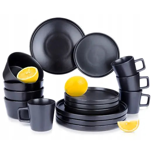 Middagsservise i matt svart keramikk, tallerkener, skåler og kopper dekorert med sitronskiver.