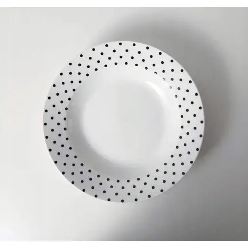 Hvit middagstallerken med sorte prikker langs kanten, sett ovenfra, fra servisesettet på 18 deler.