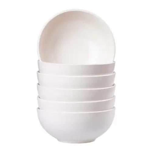 Seks hvite, glaserte skåler fra servisesettet, stablet i høyde med glatt, minimalistisk design.