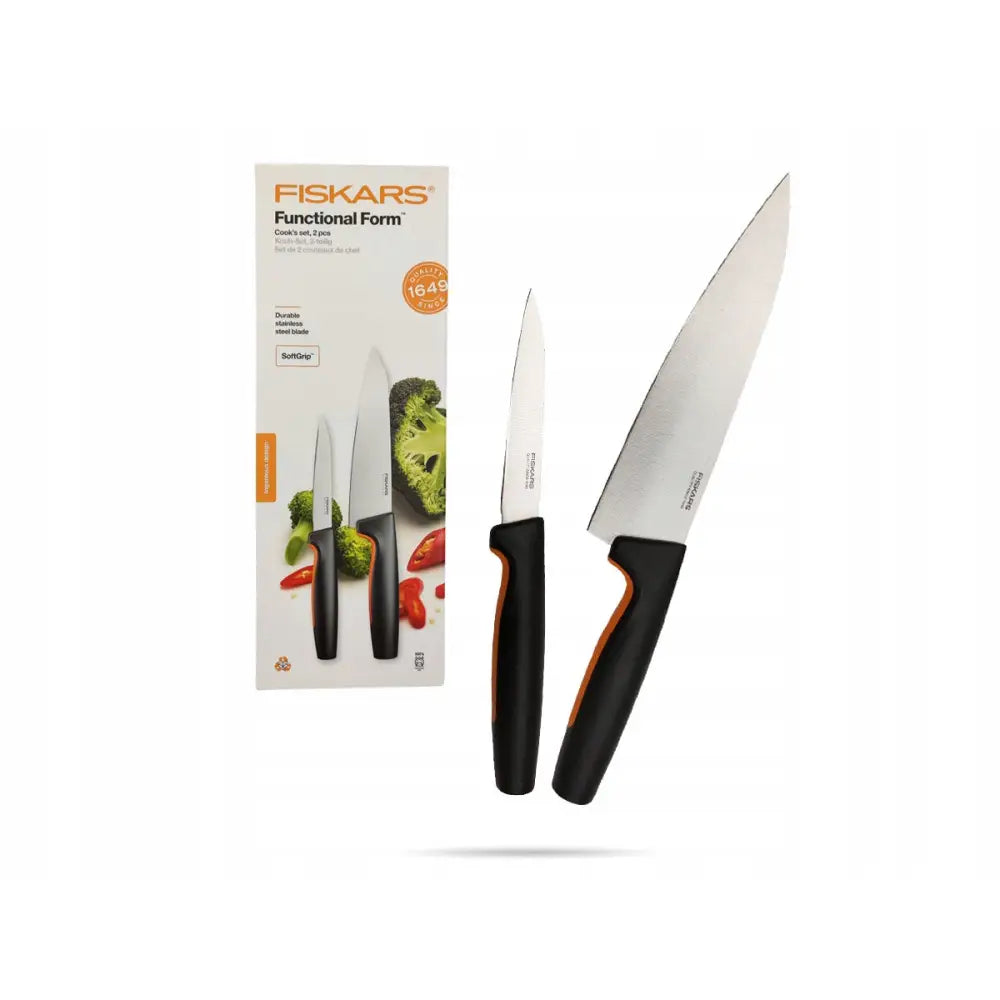 Sett med to Fiskars Functional Form kjøkkensjeferkniver med stålblad og sorte håndtak, vist ved siden av emballasjen.