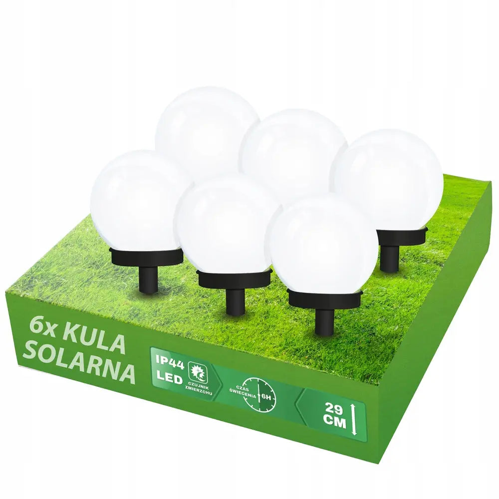 Sett med seks hvite, runde LED solcellelamper med sorte sokler, plassert på grønn eske med gressmønster.