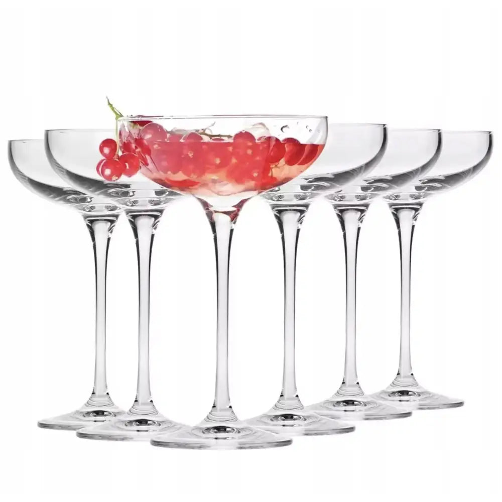 Sett med flate champagneglass, seks glass på rekke med ett glass fylt med røde bær og isbiter.