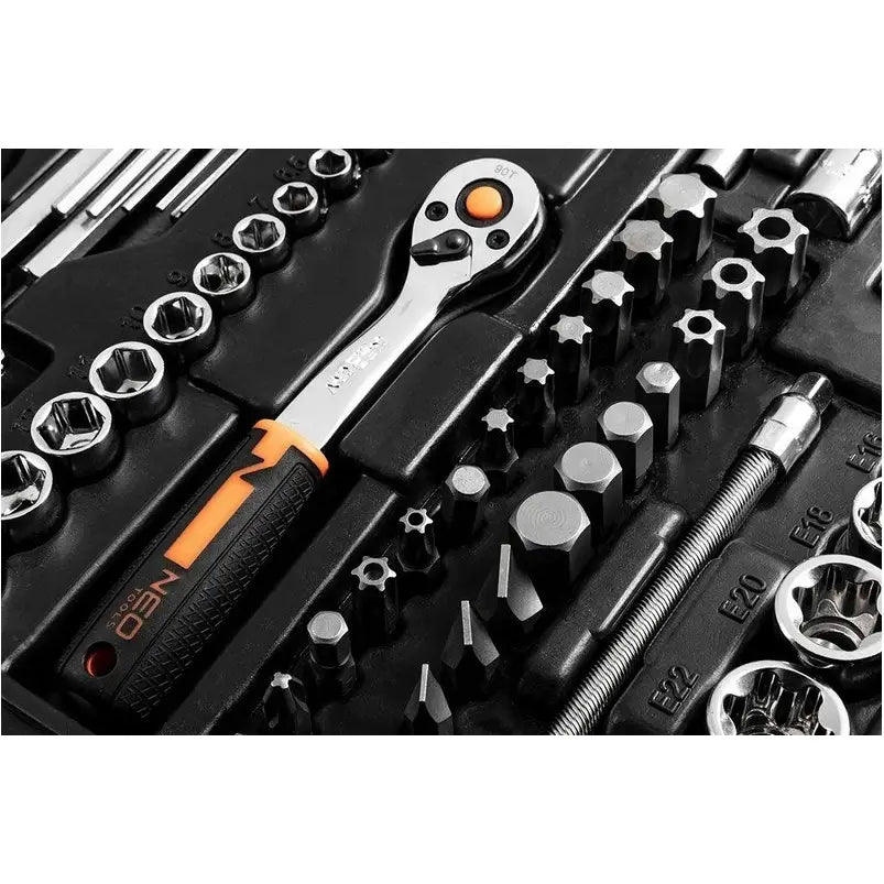 Skrallesett med piper og bits, sort og oransje, organisert i formstøpt plastkoffert, nærbilde.
