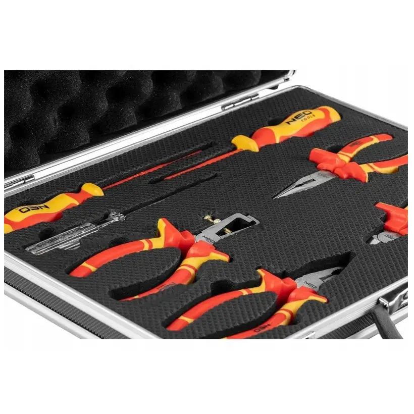 Sett med tang og skrutrekkere, 7 deler med røde og gule håndtak i formskåret skum, skrått ovenfra.