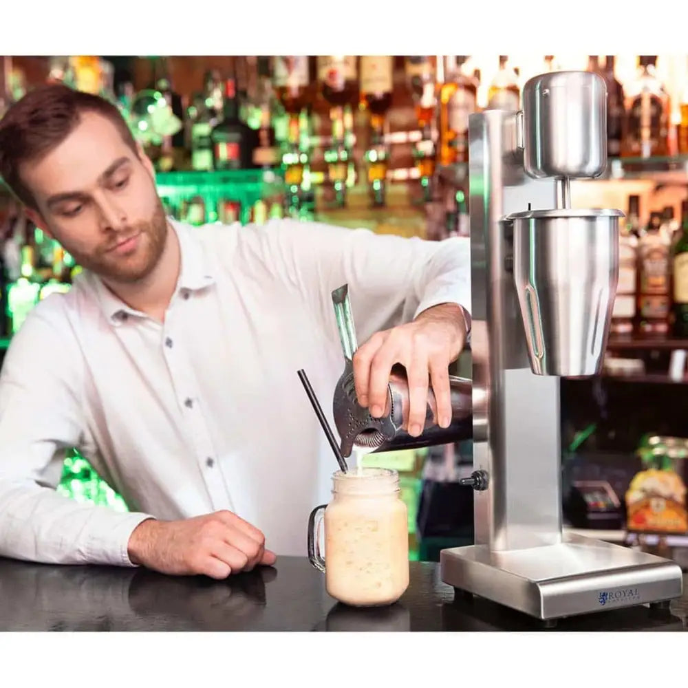 Shaker blenderbar cocktail smoothie shake, bartender heller kremet drink fra metallshaker i glasskrus ved mikser.