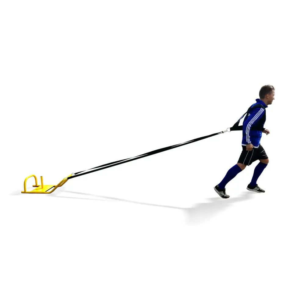 Sikkert treningsvekt 9 kg, gul metallkjelke trekkes sidelengs av person i blått treningstøy med sorte stropper.