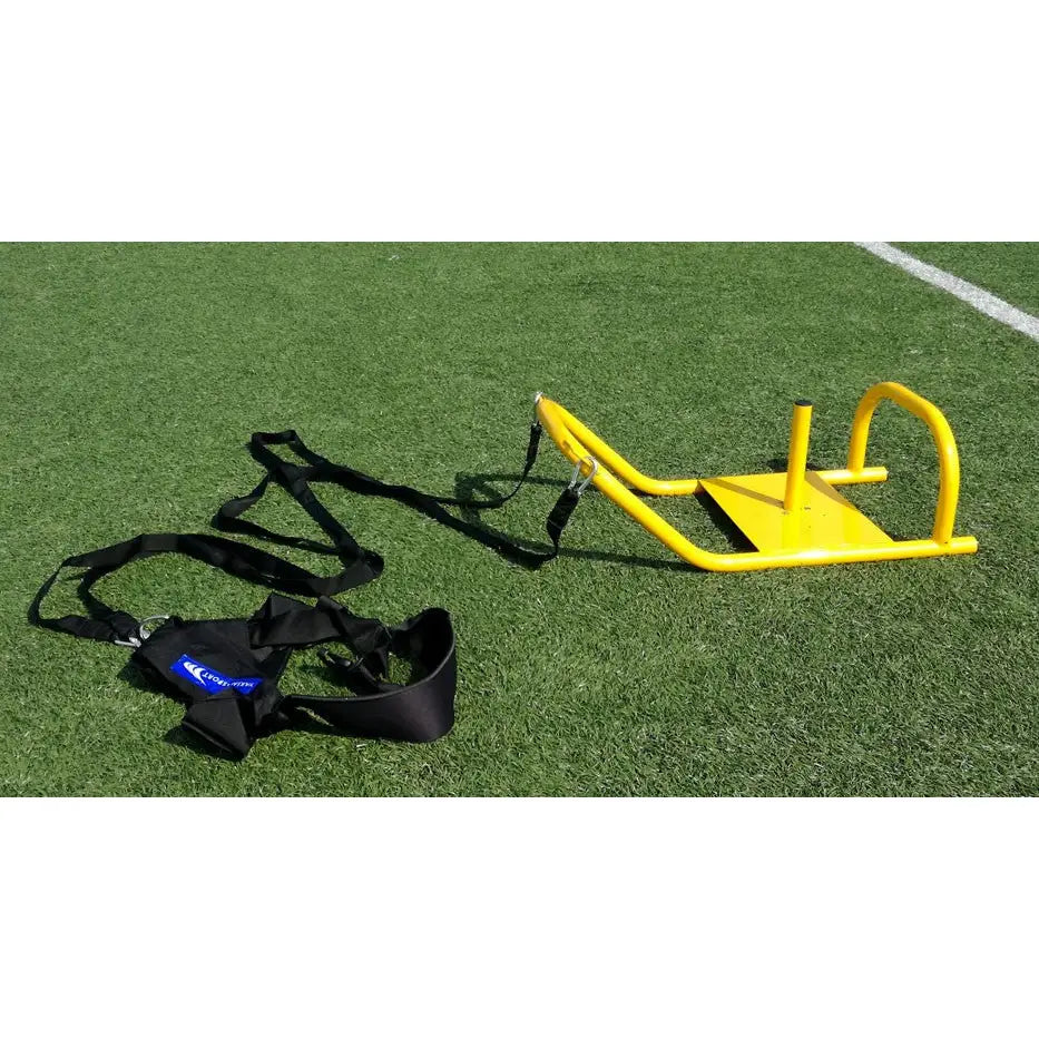 Sikkert treningsvekt 9 kg, gul konstruksjon med bøyle og stang, festet til sorte stropper på kunstgress.