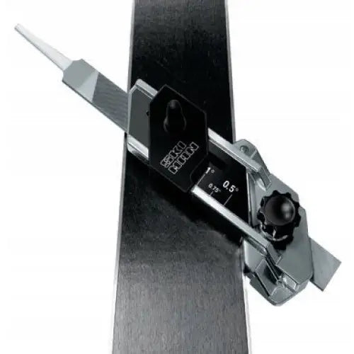 Ski Man universalt justerbart skråningsverktøy i metall, brukt på ski med synlige graderingsmerker og sort håndtak.