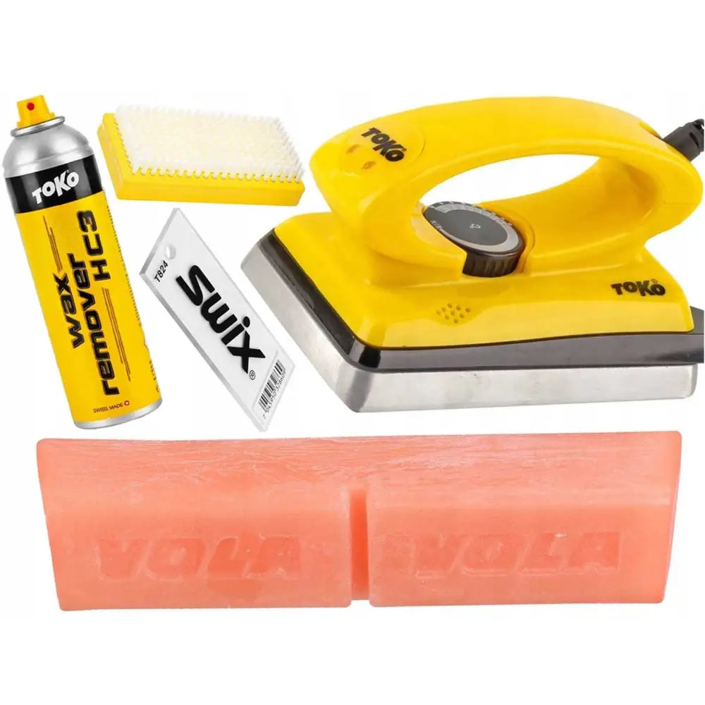 Ski smøreset for varm voksing med gult strykejern, voksfjerner, plastbørste, skrape og rosa voksblokk.