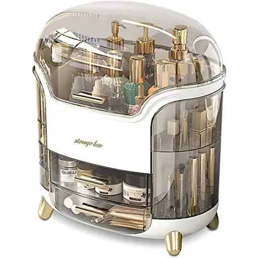 Skrin Organizer Koffert, gjennomsiktig boks med gullfargede ben og flere rom for sminke og tilbehør.