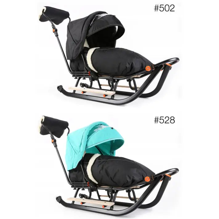 Slede for barn med svart og turkis kalesje, sidevisning av sete, fotpose og håndmuffe med LED-lys.