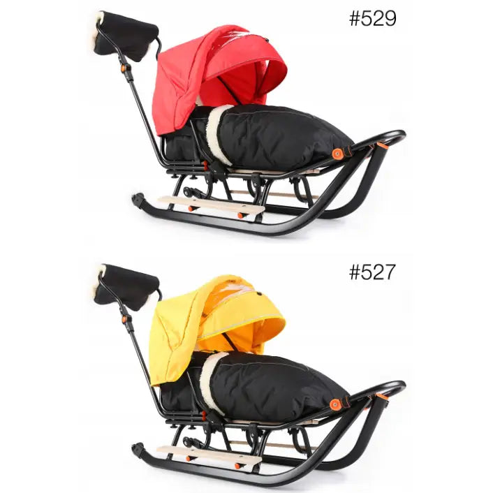 Slede for barn med metallmeier, svart ramme, isolert trekk og kalesje i rødt og gult, sett fra siden.