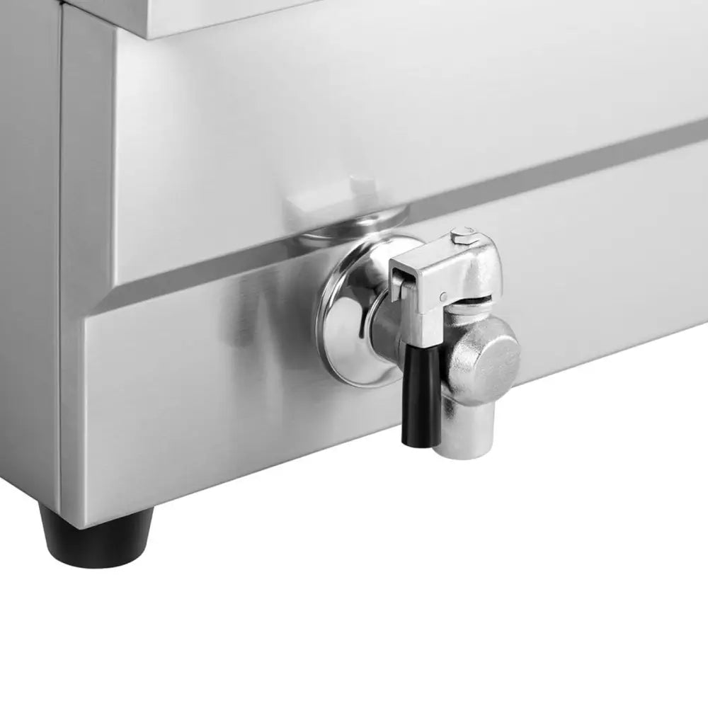 Småkoker for fisk og pommes frites, nærbilde av metallkran med sort håndtak på rustfritt stål.