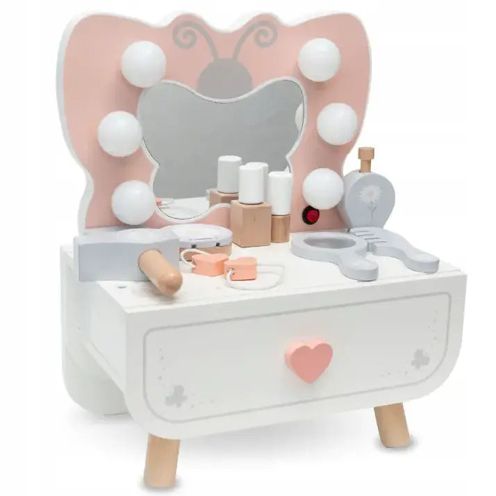 Sminkebord for barn i hvitt og rosa tre, sommerfuglformet speil og små tilbehør som kam og flasker.