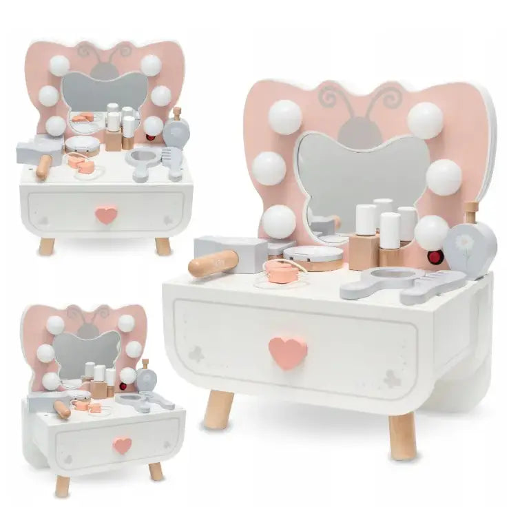 Sminkebord for barn i tre, sommerfuglformet speil, lyse ben, børste og sminketilbehør fra siden.