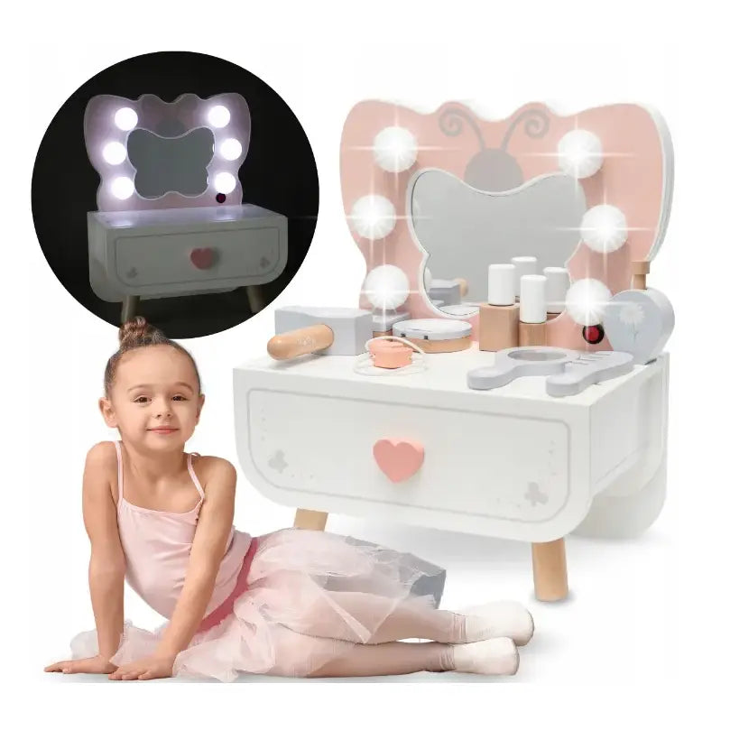 Sminkebord for barn i tre med sommerfuglformet speil, rund belysning og sminkeartikler, jente i ballettkostyme.