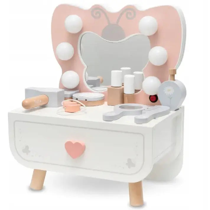 Sminkebord for barn i hvitt tre, sommerfuglformet speil, rosa detaljer og små sminkeprodukter på bordplaten.