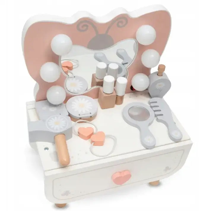 Sminkebord for barn i hvit og rosa med sommerfuglspeil, hårbørste og sminketilbehør på bordplaten.