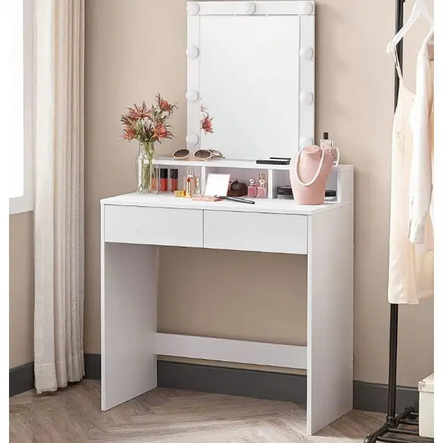 Sminkebord i hvitt med belyst speil, to skuffer, pyntet med smykker, parfymer og blomster i vase.