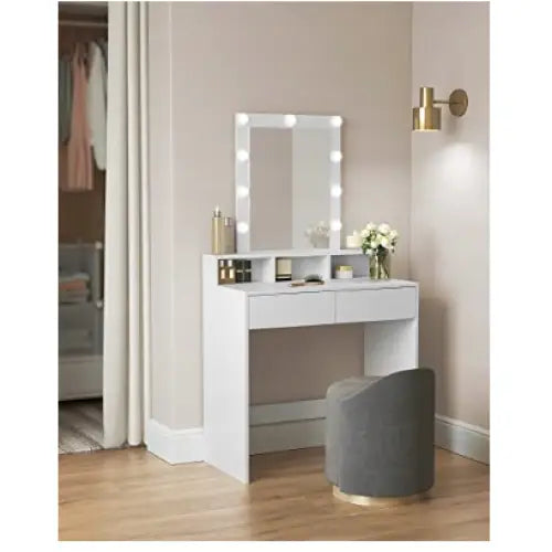 Sminkebord i hvitt med LED-speil, sett skrått, grå puff med gullsokkel og dekorative detaljer på bordet.