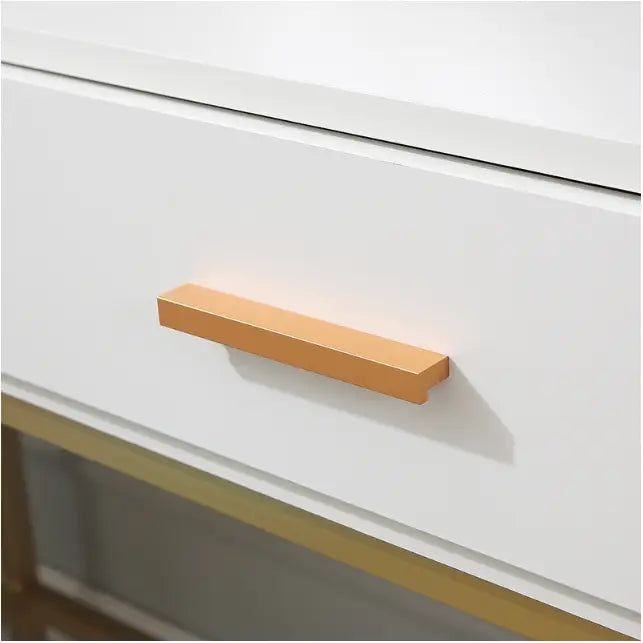 Sminkebord i loft-stil, hvit skuff med rektangulært gullhåndtak og gyllen list, sett fra skrå vinkel.