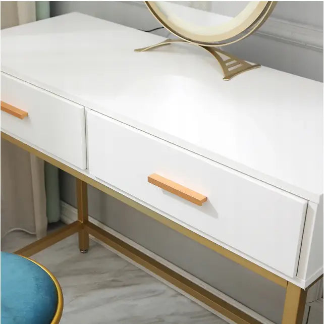 Sminkebord i loft-stil med LED-speil, skrå forfra, viser hvite skuffer, gullben og blå stol i hjørnet.