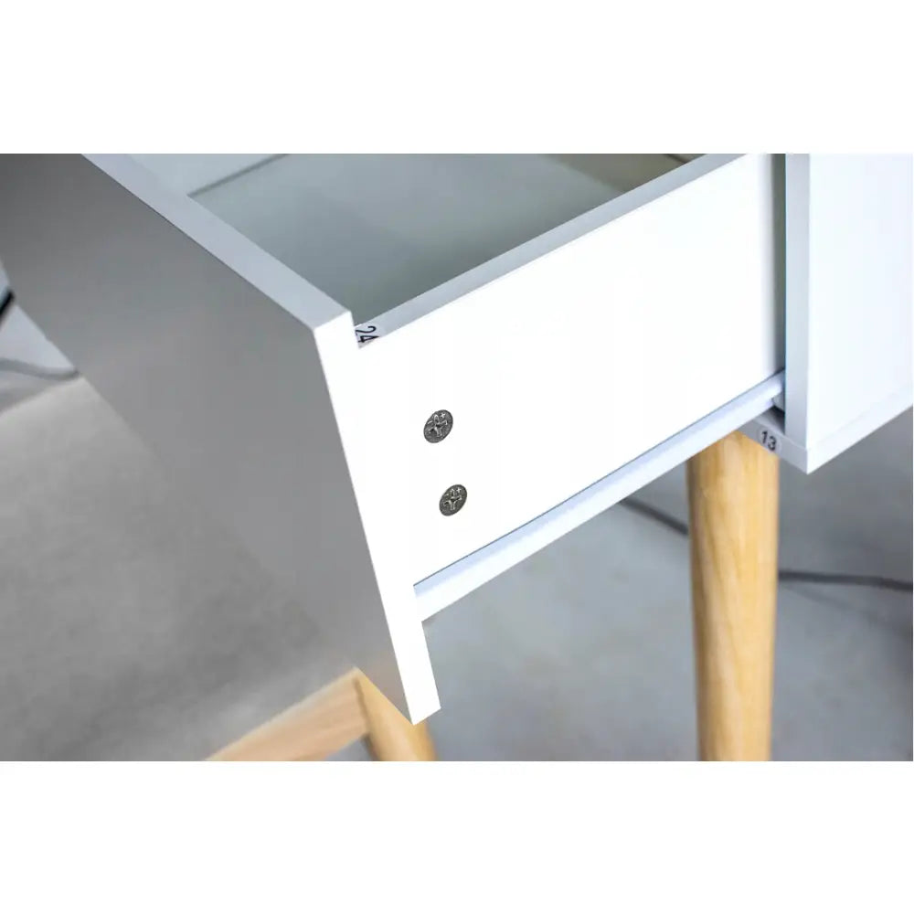 Skuff i hvitmalt tre fra sminkebord med LED-speil, delvis åpen og detaljerte lyse treben synlige.