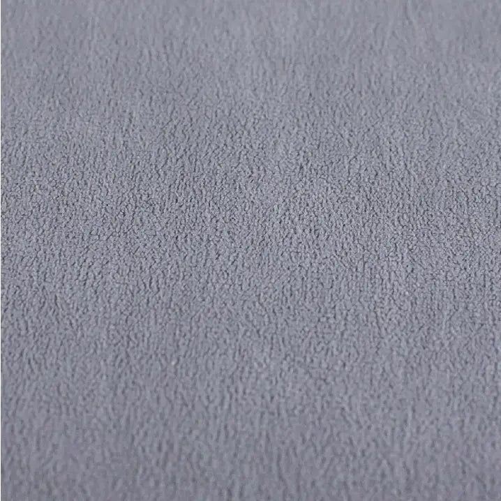 Lysegrått semsket stoff på sminkebord, nærbilde som viser myk tekstur og smånuppede detaljer.