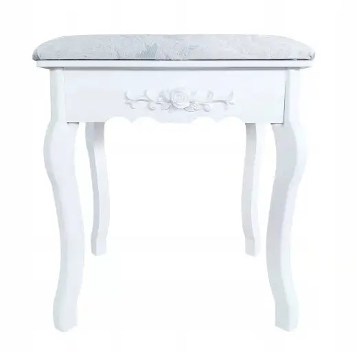 Hvit krakk med buede treben og polstret lyst sete, frontvisning med dekorativ blomsterdetalj på framsiden.