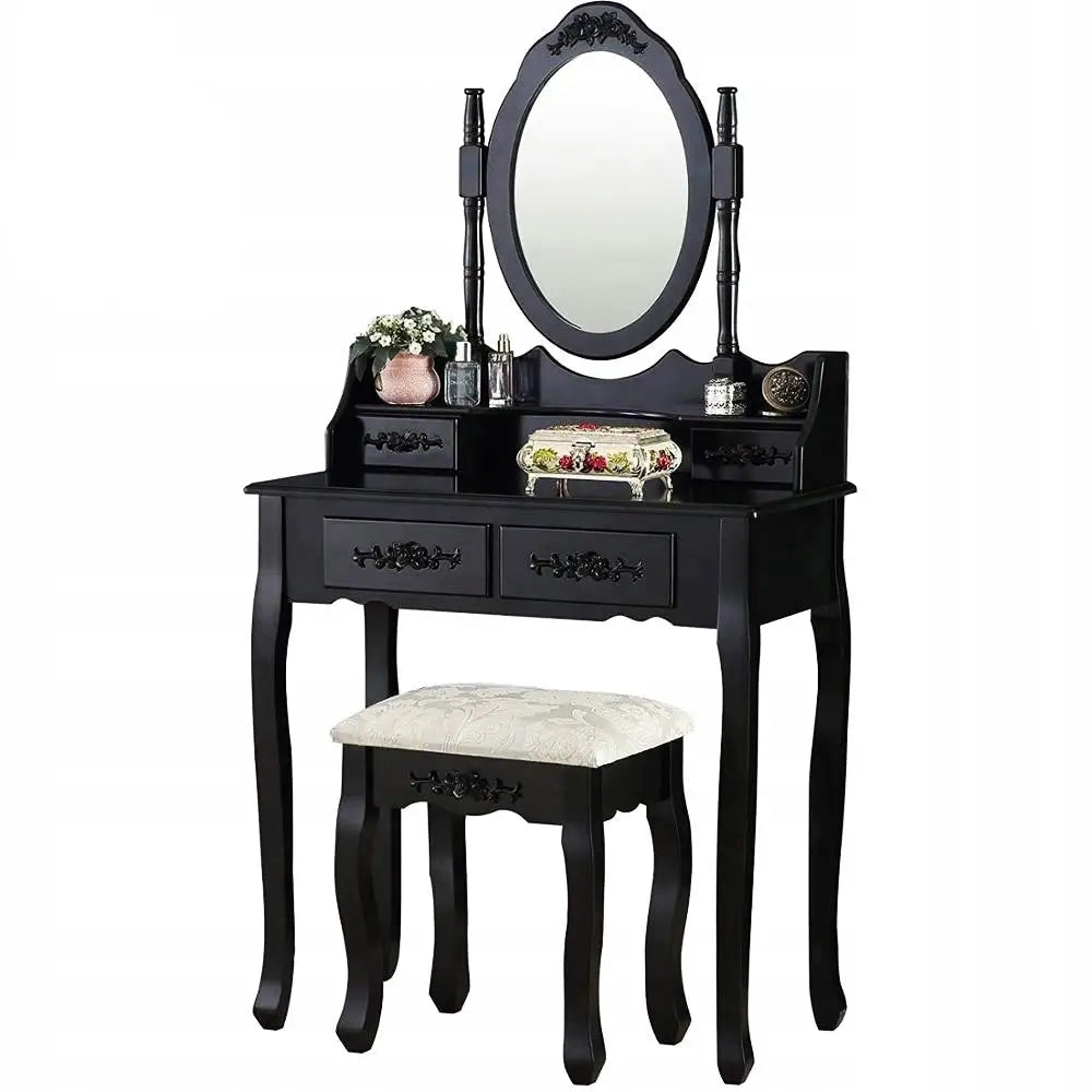 Svart sminkebord med ovalt speil, utskårne detaljer og krakk med lyst, mønstret sete, sett forfra.