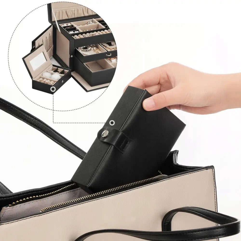 Smykkeskrin organisator i svart skinn, plassert i beige veske, med fokus på smykkelommer, rom og speil.
