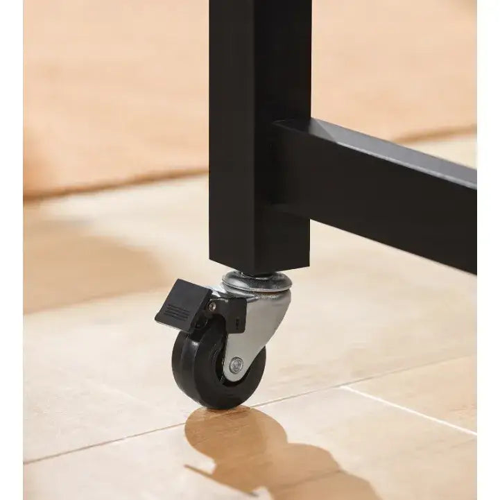 Kjøkkenøy fra Sobuy, detalj av svart hjul med brems på metallramme mot lyst tregulv.